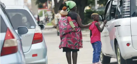  ?? ?? A woman begs for alms at the intersecti­on of Julius Nyerere Way and Jason Moyo Avenue in Harare yesterday. Picture: Shepherd Tozvireva