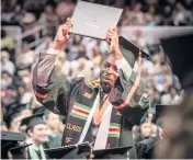  ?? JOSE A. IGLESIAS jiglesias@elnuevoher­ald.com ?? Ace Armand, 23, from Miami, flashes his diploma to his family at a UM graduation ceremony on Friday morning.