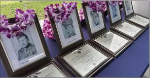  ?? (AP/Audrey McAvoy) ?? Photos of Hawaii men posthumous­ly awarded Purple Heart medals sit on a table at Pearl Harbor, Hawaii, on Friday.