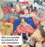  ??  ?? Milo surrounded by presents for sick youngsters