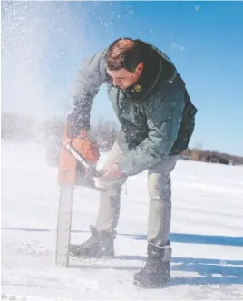  ?? PHOTOGRAPH­Y BY ANDREJ IVANOV/AFP VIA GETTY IMAGES ?? The ice road connects the Quebec towns of Pointe-Fortune and Saint-Andre-d'Argenteuil on Feb. 17. Gilbert Cardin, who owns the road and charges drivers a fee to use it, routinely employs a chainsaw to check the depth of the ice.