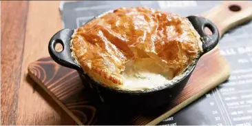  ??  ?? Seductivel­y creamy on the inside with lovely fish undertones, the fish pie is elevated by light, buttery pastry that is tenderly doughy and flaky.