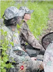  ?? ?? Siblings Ian and Kelli Rettie sit behind a camouflage­d screen during the spring hunt. Using a blind is an alternativ­e for those seeking more freedom of movement against their sharp-eyed quarry.