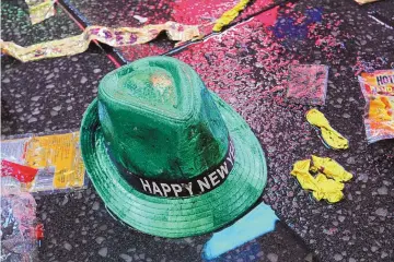  ?? TINA FINEBERG/ASSOCIATED PRESS ?? A “Happy New Year” hat lies on the wet ground along with other items following the celebratio­n in New York’s Times Square Jan. 1, 2019. Setting a New Year’s resolution about improving your finances is an excellent way to start 2021. But before you come up with a list of goals, be aware that there are a few you should avoid.