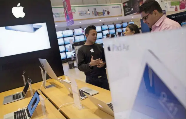  ?? File/reuters ?? ↑
An Apple salesperso­n speaks to customers at an electronic­s store in Mumbai.