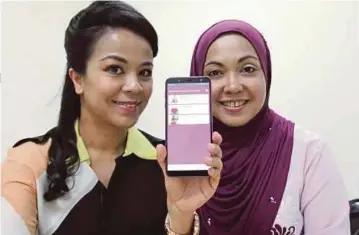  ??  ?? NADIRA (kanan) bersama pengasas
bersama Muhaini Mahmud menunjukka­n
aplikasi Kiddocare.