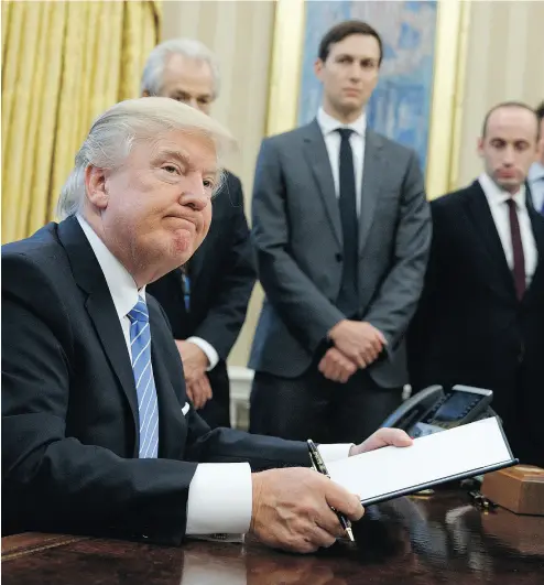  ?? EVAN VUCCI / THE ASSOCIATED PRESS ?? President Donald Trump looks up after signing the final of three executive orders on Monday.