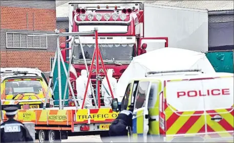  ?? BEN STANSALL/AFP VIA GETTY ?? British forensic officers work by a lorry found east of London on Wednesday carrying what police believe to be 39 dead Chinese nationals.