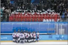  ?? FELIPE DANA — THE ASSOCIATED PRESS ?? North Korea supporters, top, wave the Korean unificatio­n flag as players of combined Koreas gather at the end of a women’s hockey game against Switzerlan­d on Saturday.