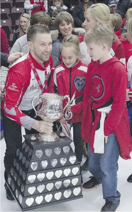  ?? ANDREW VAUGHAN/THE CANADIAN PRESS ?? Brad Gushue of St. John’s, N.L., shows the Brier Tankard to members of his family after his rink’s win over Team Canada in the final of the Tim Hortons Brier Sunday in St. John’s.