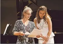  ??  ?? LISA SAFFER, left, talks with soprano Clare Demer as student musicians rehearse at a SongFest program class.