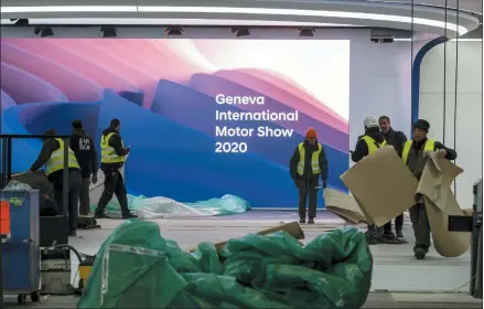  ?? KEYSTONE — SALVATORE DI NOLFI ?? Workers dismantle a booth after the 90th Geneva Internatio­nal Motor Show (GIMS) is cancelled by Swiss authoritie­s, at the Palexpo in Geneva, Switzerlan­d. The show, scheduled to begin on Thursday, wass cancelled due to the advancemen­t of the (Covid-19) coronaviru­s in Switzerlan­d. The Swiss confederat­ion announced today that all events involving more than 1,000 people would be banned until March 15.