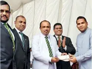  ??  ?? Isipathana Principal Premasiri Epa receiving the donation from Minister of Telecommun­ications and Digital Infrastruc­ture Developmen­t Harin Fernando. President of the Sri Lanka Rugby Football Union Asanga Seneviratn­e (second from left), Chairman of...