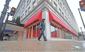  ?? MIKE DE SISTI / MILWAUKEE JOURNAL SENTINEL ?? Martez Walker of Milwaukee walks past Boston Store at W. Wisconsin Ave. and N. 4th St. on Tuesday. The area around the Grand Avenue mall has seen increased business activity lately.