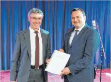  ?? FOTO: BLANKENHOR­N ?? Schulrat Bernd Schlecker (links) und der neue Schulleite­r der Eugen-BolzRealsc­hule Martin Burr (rechts) bei der Übergabe der Einsetzung­surkunde.