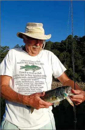  ?? NWA Democrat-Gazette/FLIP PUTTHOFF ?? Culmer shows a largemouth bass he caught Sept. 3 with a top-water lure. He hits the water at first light to catch bass chasing shad on the surface.