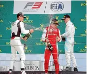  ??  ?? Marcus Armstrong, centre, gets showered in champagne as he celebrates his victory in Hungary.