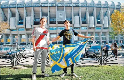  ?? REUTERS ?? Un aficionado de River y uno de Boca posan en las afueras del Santiago Bernabéu.