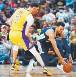  ??  ?? Nuggets guard Jamal Murray tries to pick up a loose ball Friday night as Lakers guard Lonzo Ball plays defense at the Pepsi Center. Their teams meet again Tuesday night in Los Angeles.