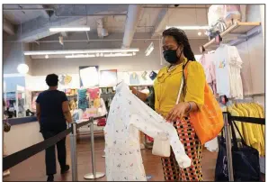  ?? (AP/Mark Lennihan) ?? A woman shops for clothing in a Gap store in New York in June. Retail sales rose in June.