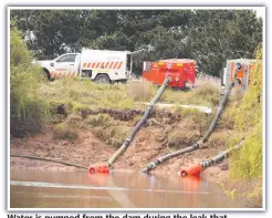  ??  ?? Water is pumped from the dam during the leak that threatened houses. Picture: ALISON WYND