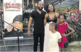  ??  ?? Scholarshi­p recipients Nicquacya Gordon (front) and Angelina Solomon (right) share a moment with Jonathan Buchanan of the Black Angel Foundation and their mother Latisha Levermore.