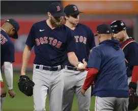  ?? Ap; LEfT, GETTy ImaGEs ?? ‘US VERSUS US’: Red Sox lefty Chris Sale, left, gives the ball to manager Alex Cora after giving up the lead in the sixth inning on Tuesday night in Baltimore, Md. At left, Orioles outfielder Ryan McKenna makes a tough catch to end the game.