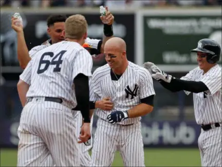  ?? PHOTOS BY JULIE JACOBSON — ASSOCIATED PRESS ?? Brett Gardner, center, is mobbed by teammates after driving in Jacoby Ellsbury with the winning run in the Yankees' 5-4 victory over Rays on Saturday.