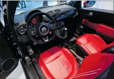  ??  ?? The interior of the 2013 Fiat 500c Abarth shows off the red leather highback performanc­e bucket seats.