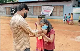  ?? — P. SURENDRA ?? It was a different kind of experience for girls at an orphanage in Musheeraba­d as they tie rakhi on Raksha Bandan in Hyderabad by maintainin­g social distancing norms.