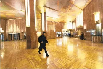  ?? MARKLENNIH­AN/AP ?? A man walks through the Chrysler Building lobby.