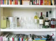  ?? LAURA AGRA/KATIE WORKMAN VIA AP ?? This November 2015 photo provided by Katie Workman shows a temporary bar for a party being set up in a bookcase in New York. Making the most of different areas of your home is very helpful when you have a big group over.