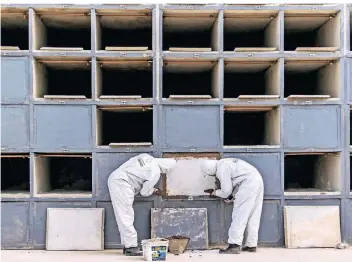  ?? FOTO: DPA ?? Arbeiter in Schutzanzü­gen auf einem Friedhof in Rio. Die Zahl der Corona-Todesfälle steigt in Brasilien stark.