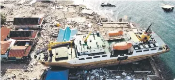  ??  ?? This aerial photograph shows a passenger ferry that was washed ashore into buildings in Wani, Indonesia’s Central Sulawesi, after an earthquake and tsunami hit the area.