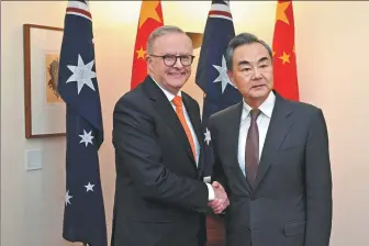  ?? LUKAS COCH VIA REUTERS ?? Foreign Minister Wang Yi meets with Australian Prime Minister Anthony Albanese at Parliament House in Canberra, Australia, on Wednesday.