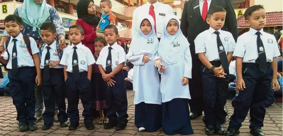  ??  ?? Double take times four: (From right) Muhammad Danish, Muhammad Danial, Nurain Athirah, Nurain Amirah, Muhammad Nur Airil, Muhammad Nur Airie, Mior Rafieq Hazieq and Mior Razieq Harith on their first day at SK Serkam Darat in Jasin.