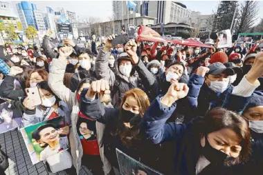  ?? REUTERS ?? Myanmar protesters residing in Japan hold photos of Aung San Suu Kyi as they rally yesterday at United Nations University in Tokyo against Myanmar’s military after it seized power from a democratic­ally elected civilian government and arrested its political leaders.