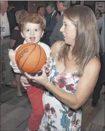  ??  ?? Emily Ferraro helps her son Frankie take a free throw.