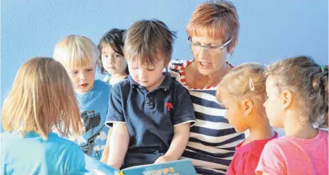  ?? FOTO: BERND WÜSTNECK, DPA ?? Vorlesen und gemeinsam Bücher anschauen ist ein Teil der Sprachförd­erung im Kindergart­en.