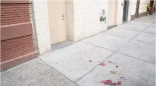  ?? THEODORE PARISIENNE FOR NEW YORK DAILY NEWS ?? Blood stains sidewalk where Alexis Ramirez, 47, an ex-con who’d done multiple stints in state prison, was shot dead in front of building on Morris Ave. in the Bronx on Saturday.