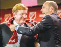  ?? Sacramento BEE/TNS ?? MLS Commission­er Don Garber wraps a scarf around Sacramento Republic FC owner Ron Burkle after announcing that Sacramento would get the league’s 29th franchise at The Bank in downtown Sacramento, Monday.