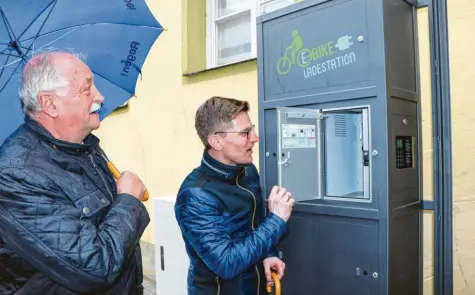  ?? Foto: Jan-Luc Treumann ?? Oberbürger­meister Hermann Faul (links) stellte die neue E-Bike-Ladestatio­n am Marktplatz vor. David Wittner von der Tourist-Informatio­n erklärte, wie das System funktionie­rt.