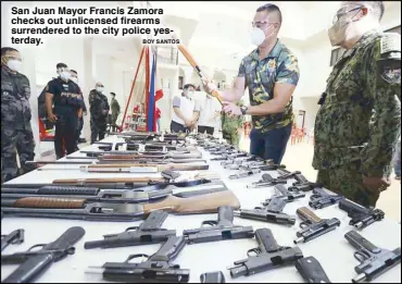  ?? BOY SANTOS ?? San Juan Mayor Francis Zamora checks out unlicensed firearms surrendere­d to the city police yesterday.