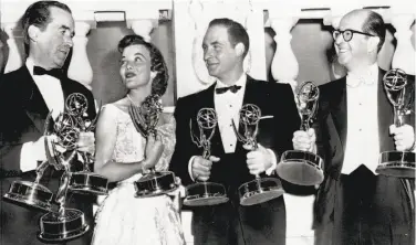  ?? Associated Press 1957 ?? Master of ceremonies Phil Silvers (right) and Emmy winners from the East Coast hold trophies at the 1957 show: Edward R. Murrow (left), winner of three awards; Nanette Fabray and comedian Sid Caesar.