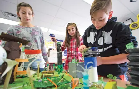  ?? GABRIELA CAMPOS NEW MEXICAN FILE PHOTO ?? From left, Leyana Hopkins, Wailea Gallegos and Reeve Trujillo work on their Future Cities Competitio­n project last year at Turquoise Trail Charter Elementary School.