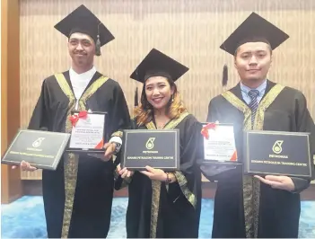  ?? ?? Syra (centre) flanked by Uzayr (right) and Sarifuddin holding their diploma.