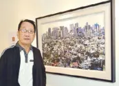  ??  ?? Steve Santos and his work, “Manila Skyline” (2018). Malang’s eldest son has had solo exhibition­s in many art spaces, and for a good part of his life also worked as an art director in various publicatio­ns in Hong Kong and the Philippine­s.