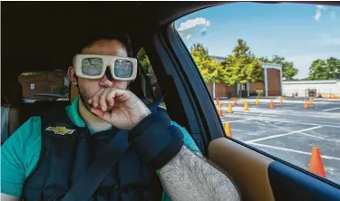  ?? Mark Mulligan / Staff photograph­er ?? Carlos De Loera wears a weighted vest, wrist weights and glasses that simulate a state of drowsiness during a public awareness campaign about drowsy driving put on by Chevrolet in Houston.