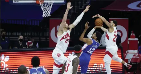  ?? MATT SLOCUM — THE ASSOCIATED PRESS ?? Sixers forward Tobias Harris, center, tries to split the defense of Toronto’s Alex Len, right, and Fred VanVleet Tuesday night. Harris scored 26 points to go with 11 rebounds in a 100-93 Sixers win.