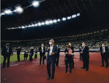  ?? BEHROUZ MEHRI — GETTY IMAGES ?? IOC president Thomas Bach, center, is adamant that the Tokyo Summer Games will be held this year. Here he is touring the National Stadium, main venue for the postponed Games, in November in Tokyo.